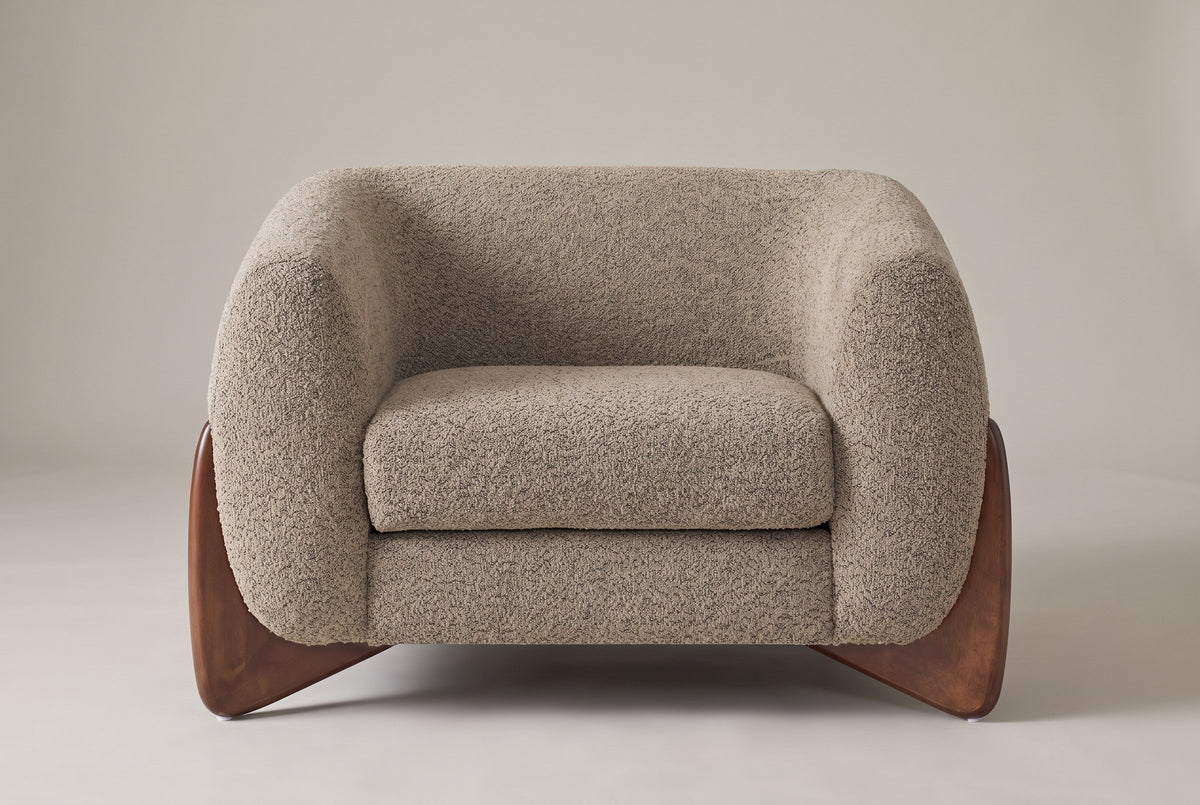 Cervia lounge chair in Light Brown boucle, straight front view on a studio backdrop