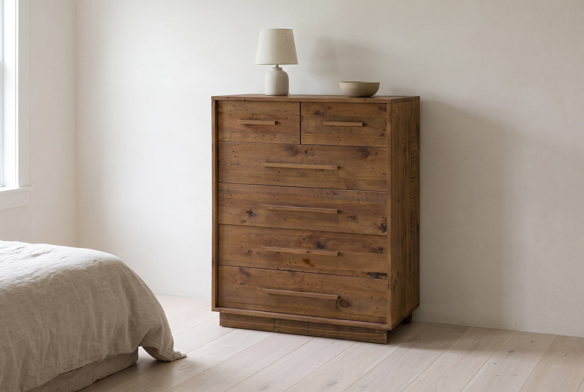 Cervinia reclaimed pine chest of drawers against a warm white plaster wall in a Fredericton, New Brunswick bedroom, a linen lamp and a stoneware bowl on top