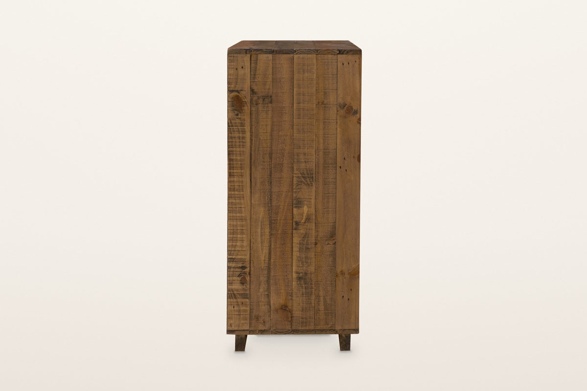 The right side of the Cervinia chest: vertical reclaimed pine planks with knots and saw marks over a low plinth