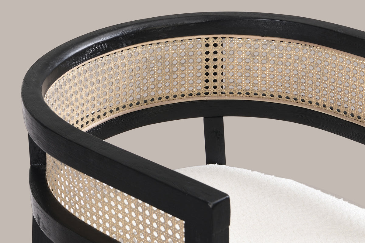Close-up of the wide curved top rail, the cane-look weave band and the arm of the Black Cesena chair
