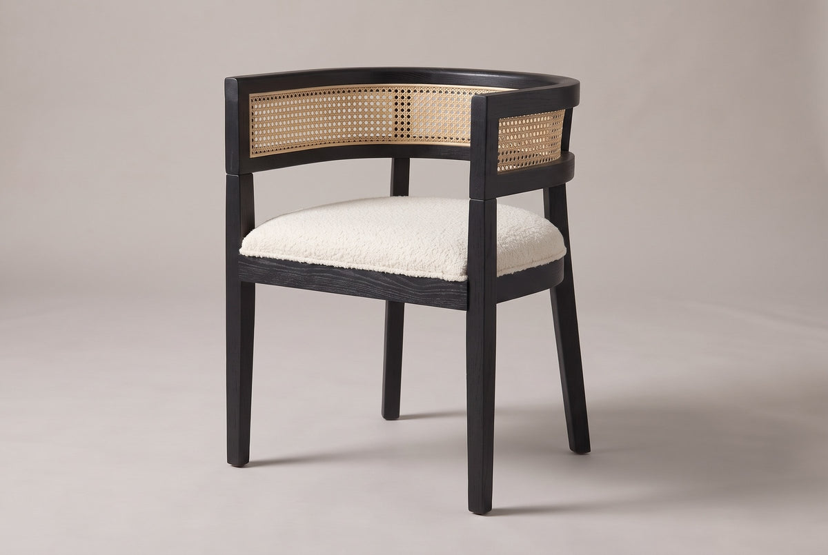 Cesena cane-back dining chair in Black, three-quarter view on a warm light-grey studio backdrop