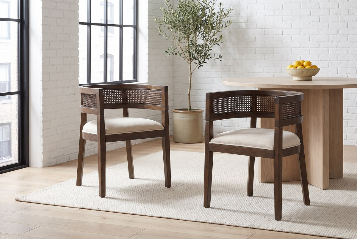 Two Cesena dining chairs in Walnut pulled out from a pale-oak pedestal table in a white-brick Montreal loft