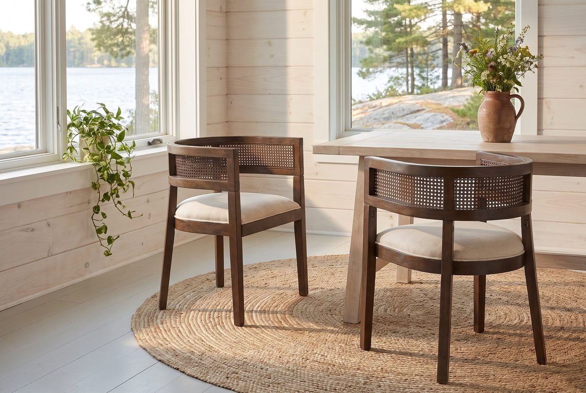 Two Cesena dining chairs on a round jute rug in a Muskoka cottage dining nook with a view of the lake