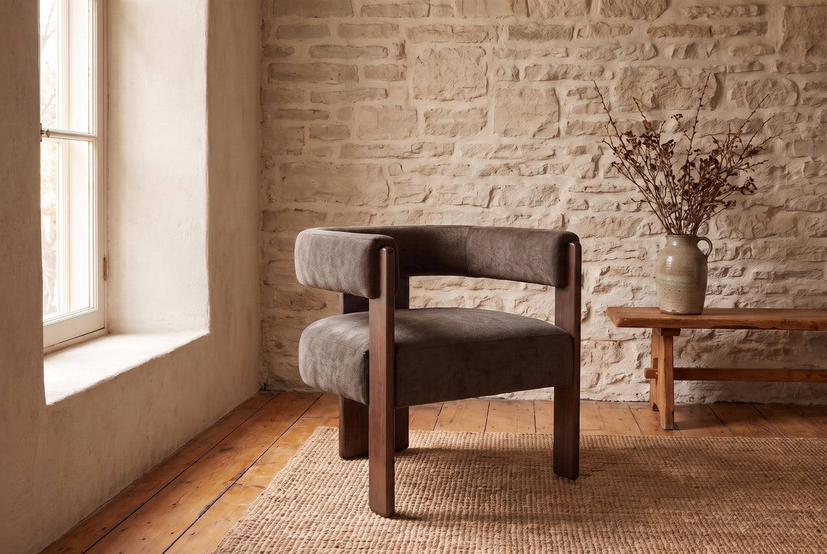 Chioggia accent chair against a limestone wall on pine floorboards and a jute rug (Dark Brown)