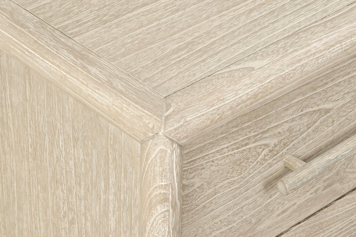 Close-up of a Chiusdino top corner: the rounded frame meeting the corner post, the whitewashed grain and a drawer pull