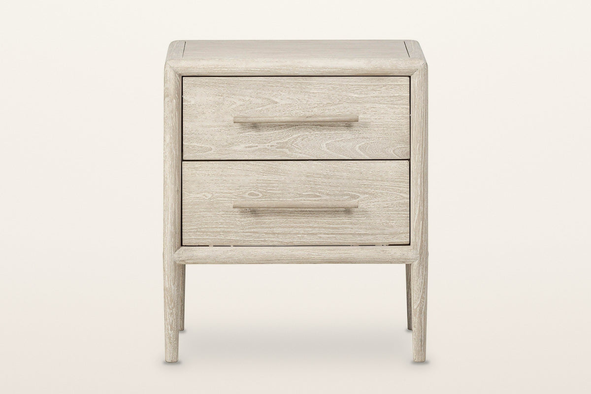 Chiusdino nightstand in whitewashed wood, front view on a warm white studio backdrop: two equal drawers
