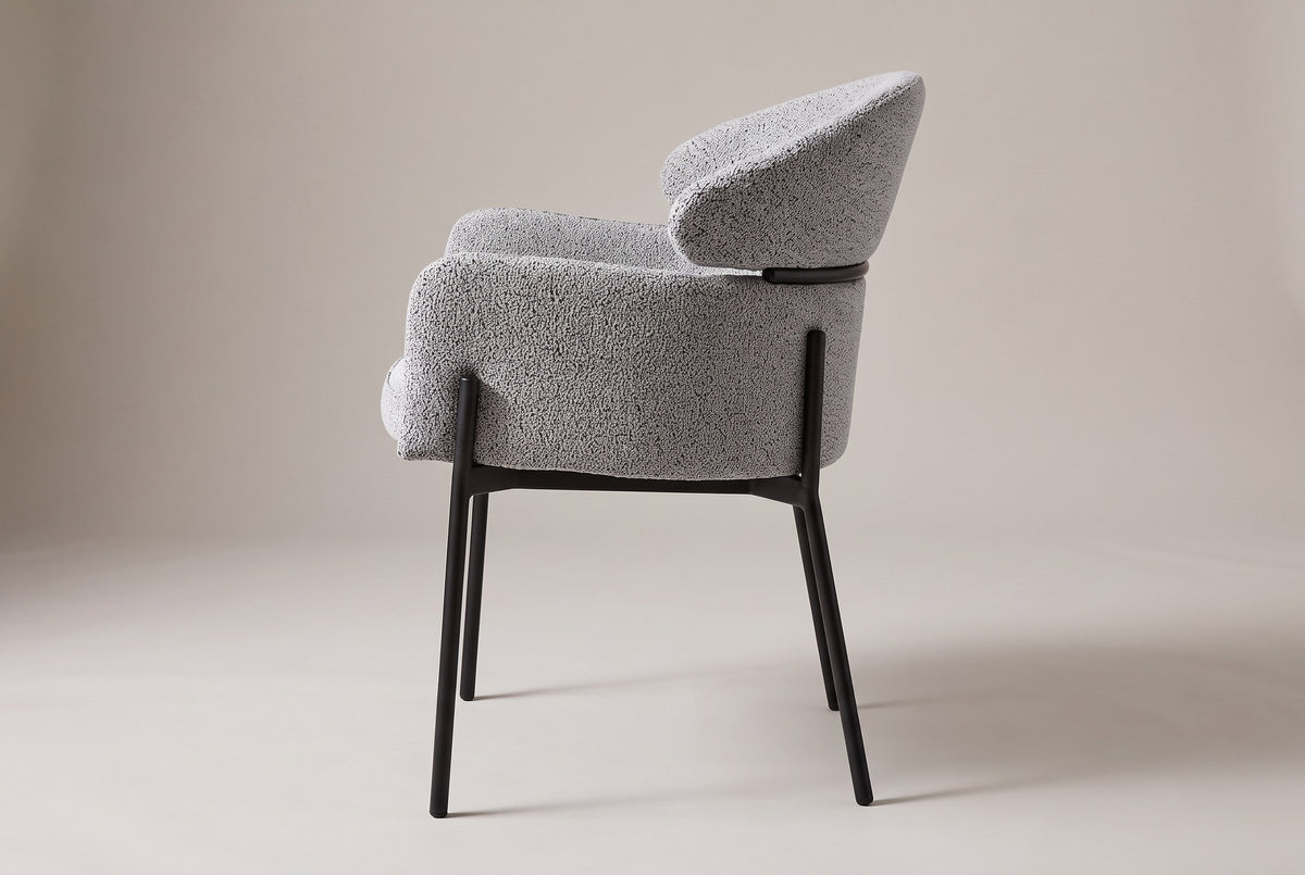 Chiusi dining chair in Light Gray boucle, side view showing the floating back pad and slim steel legs