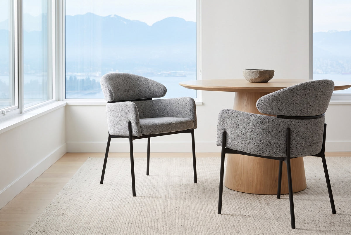 Two Chiusi dining chairs beside a round oak table in a bright Vancouver apartment with a view of the mountains