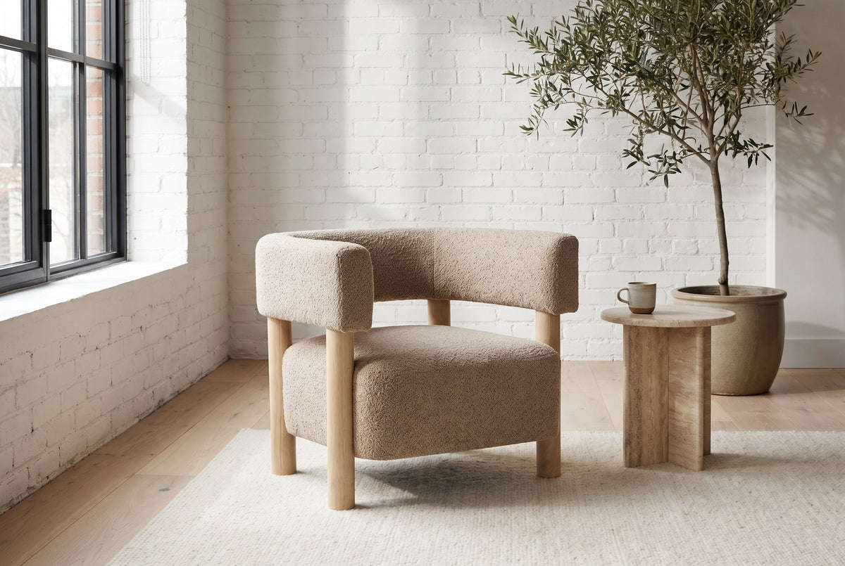Cingoli boucle chair in a Montreal loft living room with a white brick wall, a steel window and a travertine side table