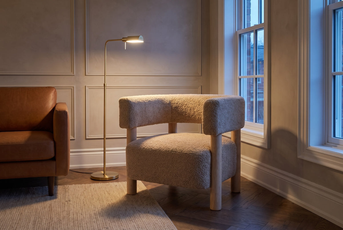 Cingoli chair beside a cognac leather sofa in an Ottawa townhouse living room at dusk, a brass floor lamp lit