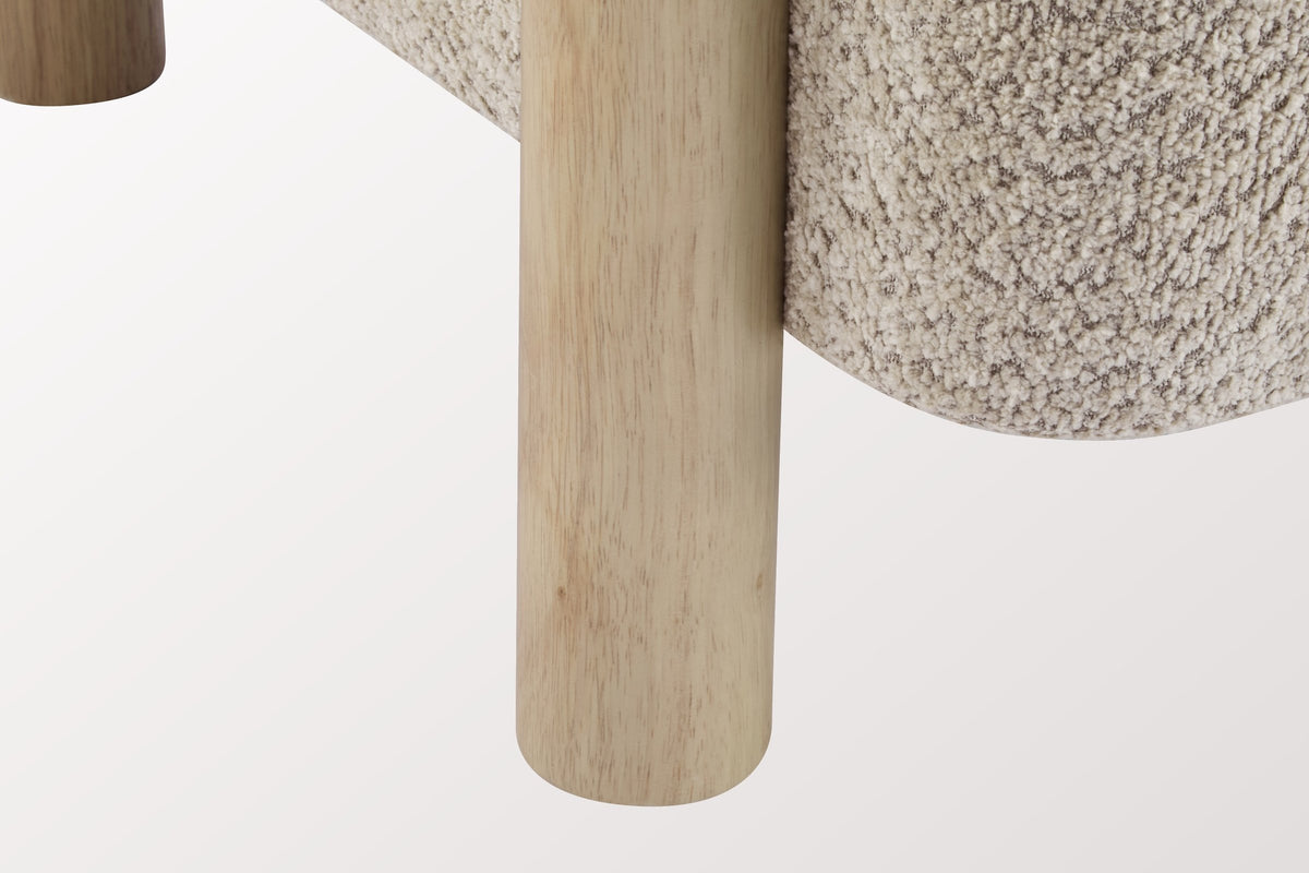 Close-up of a round natural rubberwood leg beside the rounded Wheat boucle seat of the Cingoli chair