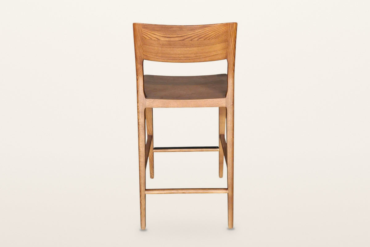 Cison counter stool in Warm Brown from behind on a warm white studio backdrop