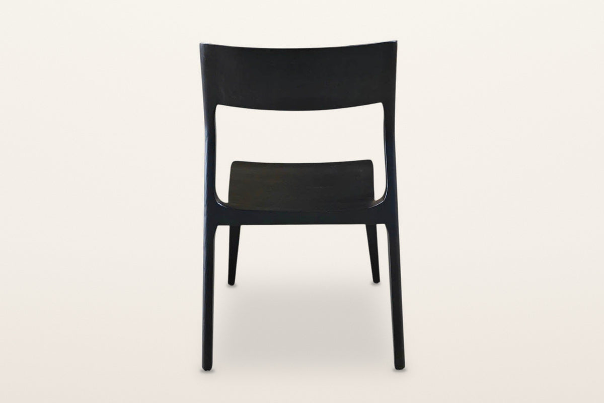 Cison dining chair in Black, back view on a warm white studio backdrop: the backrest panel and the two posts