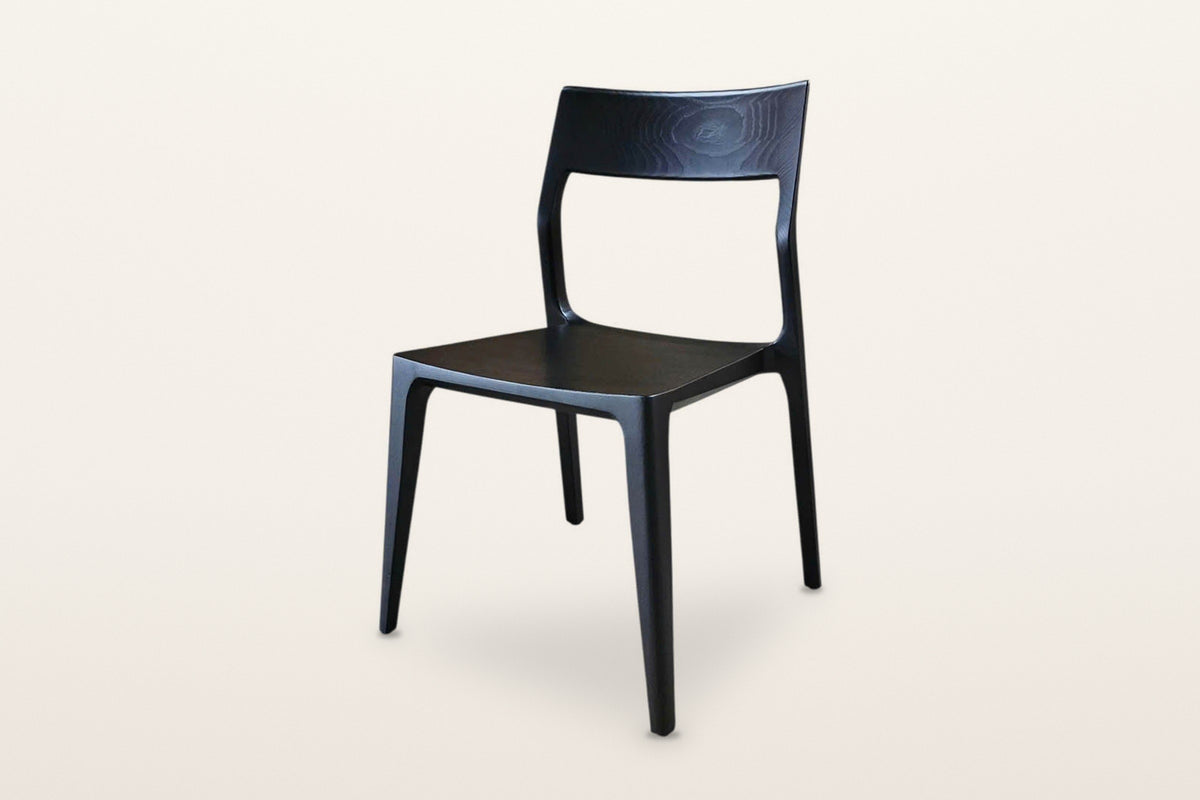 Cison dining chair in Black, three-quarter view on a warm white studio backdrop
