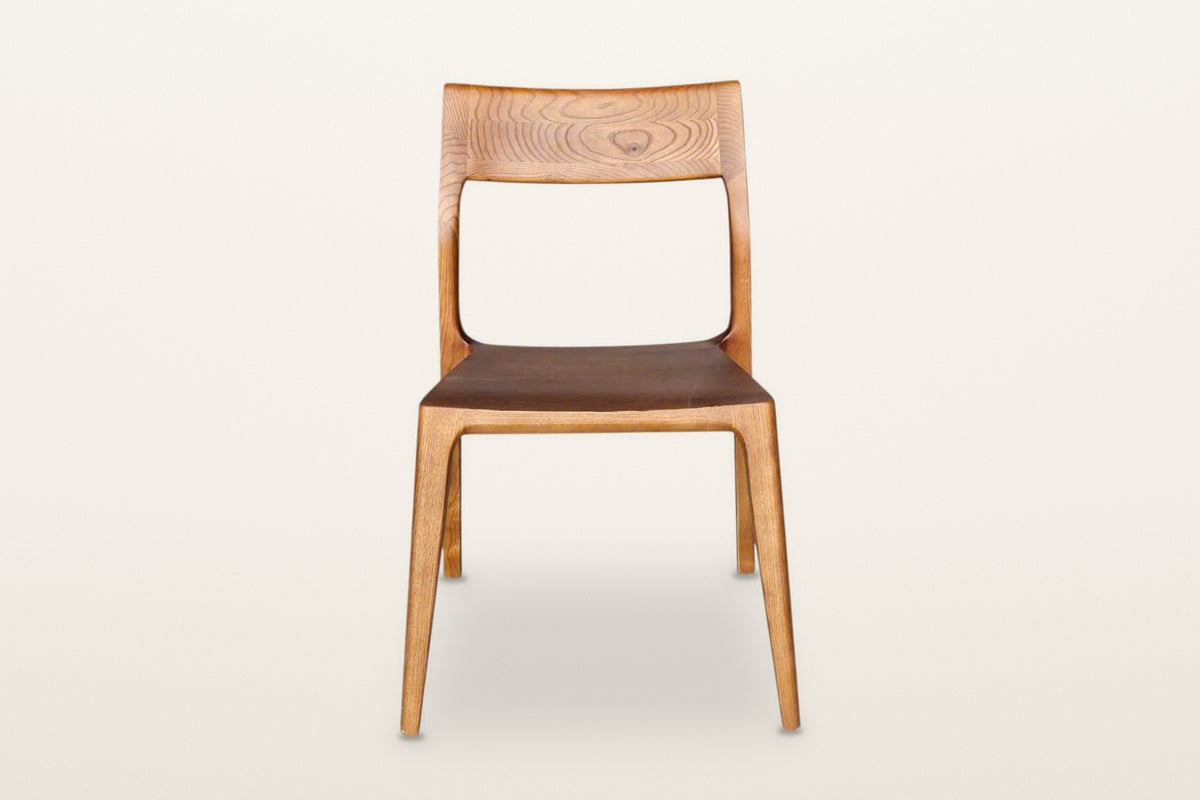 Cison dining chair in Warm Brown, front view on a warm white studio backdrop: the wide backrest on top of the posts