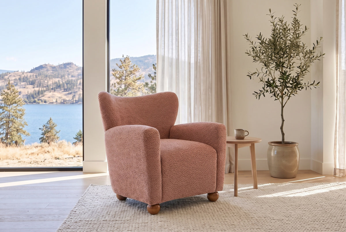 Collodi chair in Coral in a bright Kelowna lake-house living room with an olive tree and a pale oak side table