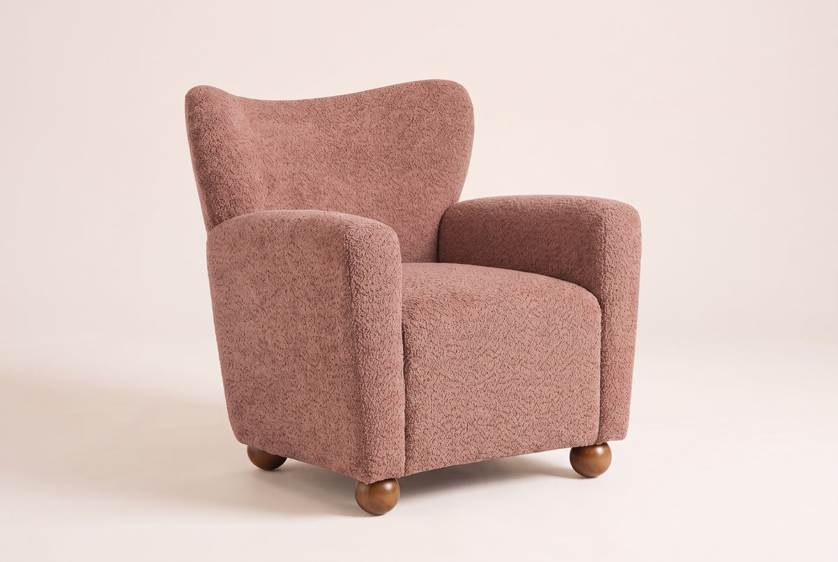 Collodi wingback accent chair in Coral, three-quarter view on a warm off-white backdrop