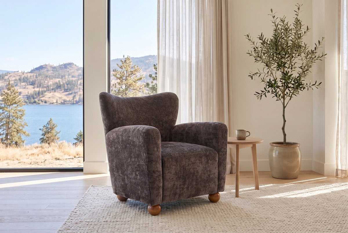 Collodi chair in Dark Brown chenille in a bright Kelowna lake-house living room with an olive tree and a pale oak side table