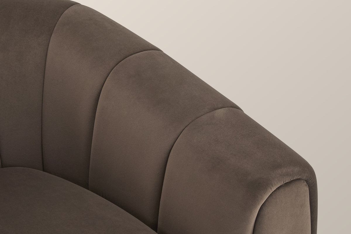 Close-up of a channelled velvet arm and its rolled front edge in dark brown