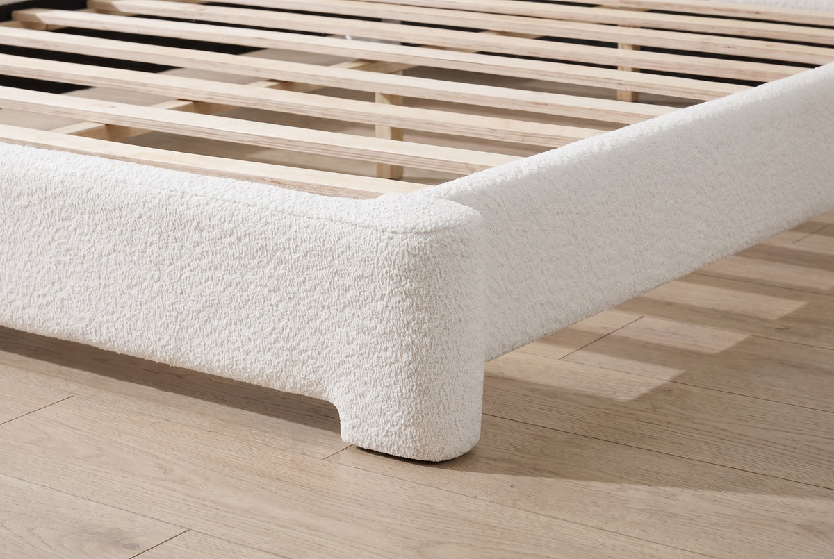 Close-up of a sculpted boucle foot at the corner of the Cupello bed
