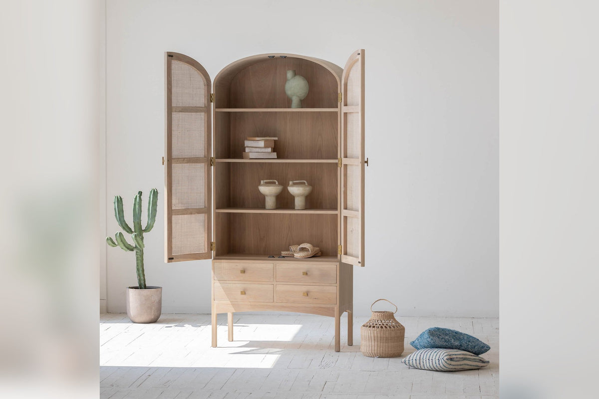 Dalton cabinet with rattan doors open, showing oak shelves styled with books and vases