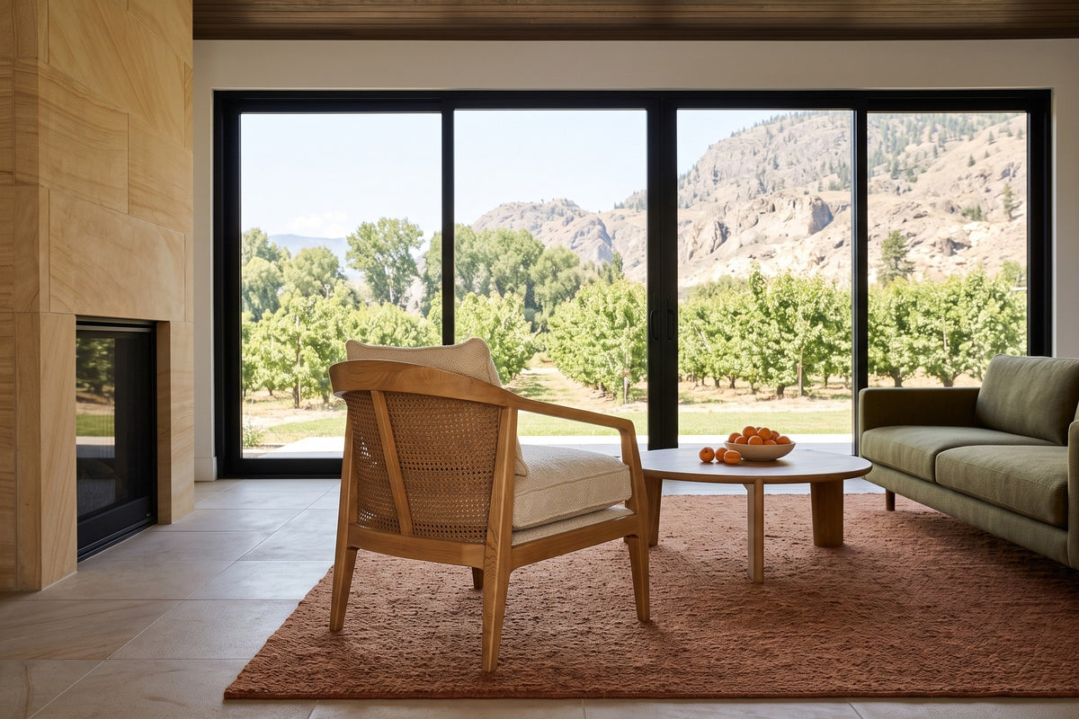 Esanatoglia accent chair seen from behind in a Keremeos orchard house, the open cane back to the camera