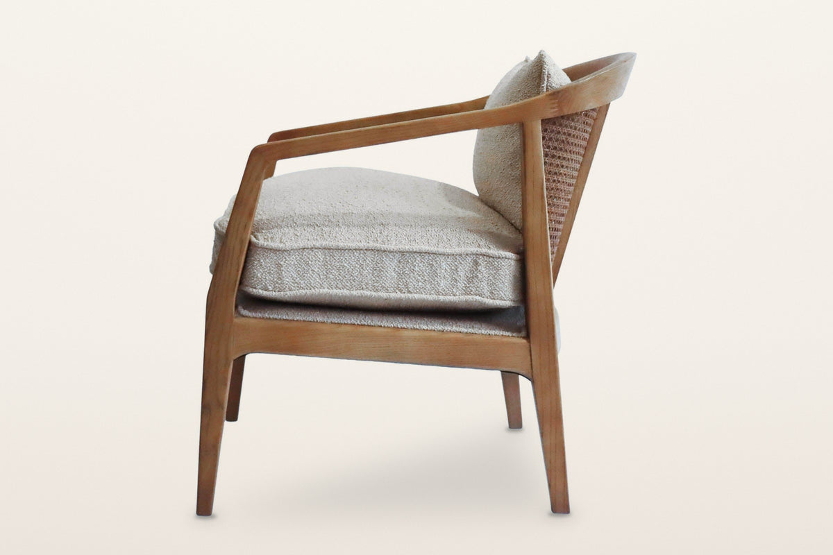 Esanatoglia accent chair from the side on a warm white studio backdrop: the band sloping down to the front leg