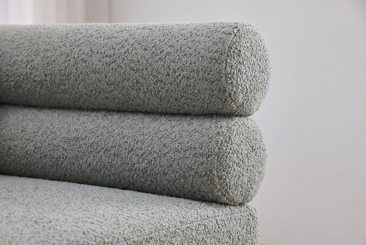Close-up of the two stacked sage boucle bolsters at one end of the Fabriano bench back