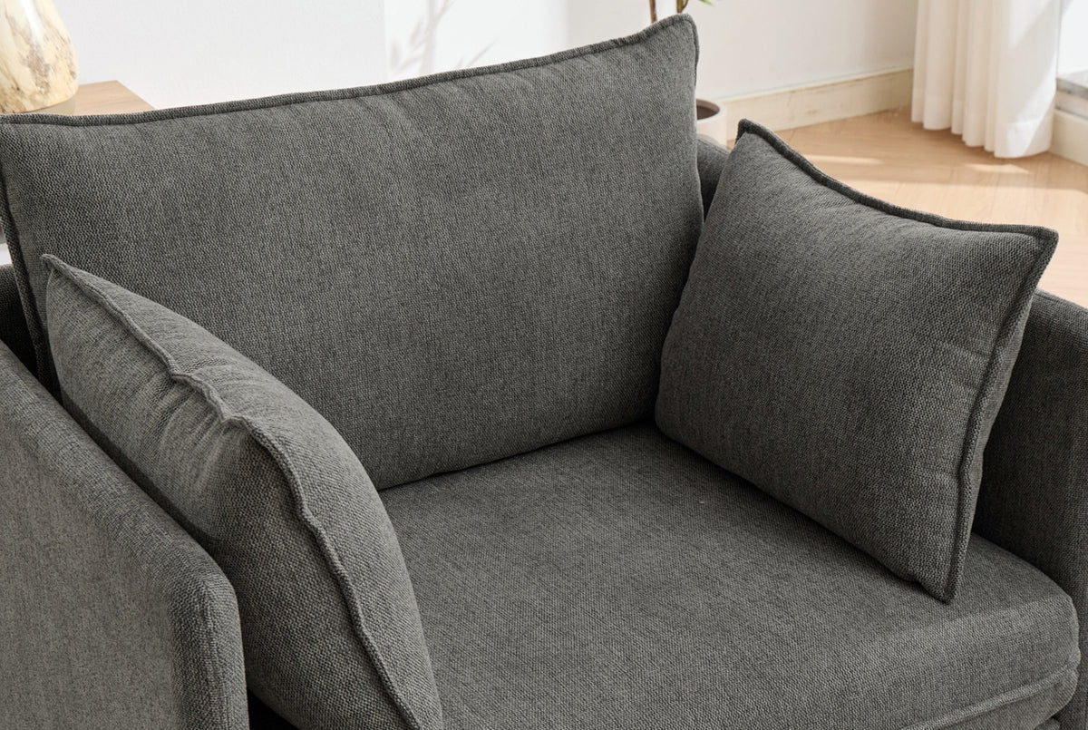 Close-up of the grey chenille chair from above: the back cushion and two throw pillows with flat flange edges