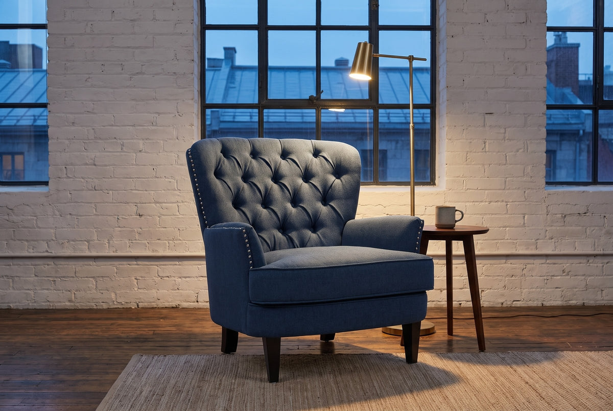 Feltre chair in a Montreal loft in the evening, whitewashed brick and a brass floor lamp lit beside it