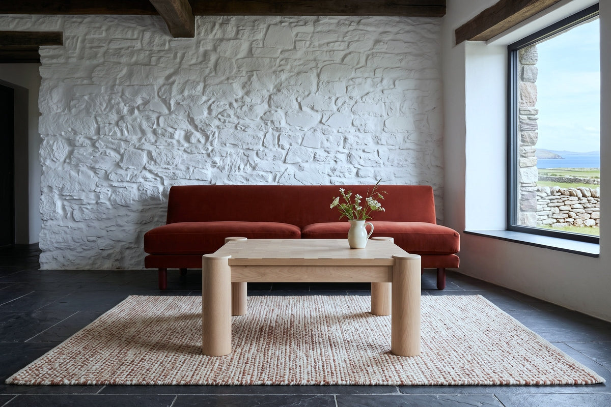 Furore coffee table in Biscotti Oak seen low from the front in a Dingle farmhouse, with whitewashed rubble stone