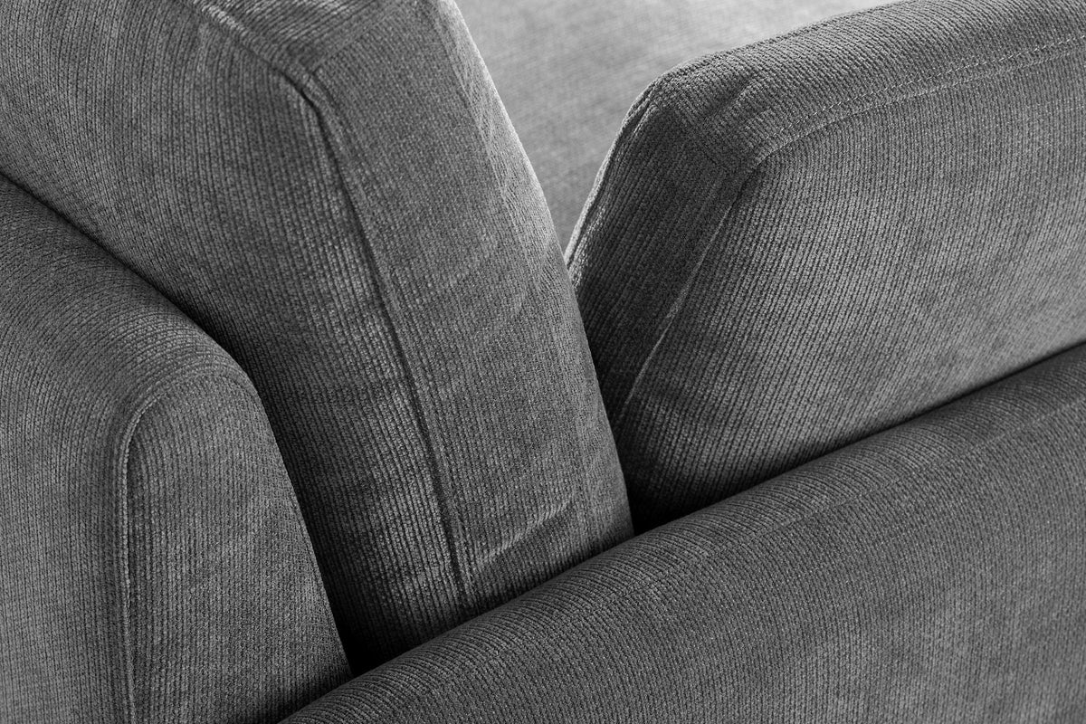 Close-up of the ribbed charcoal gray chenille where the arm, the back cushion and a pillow meet