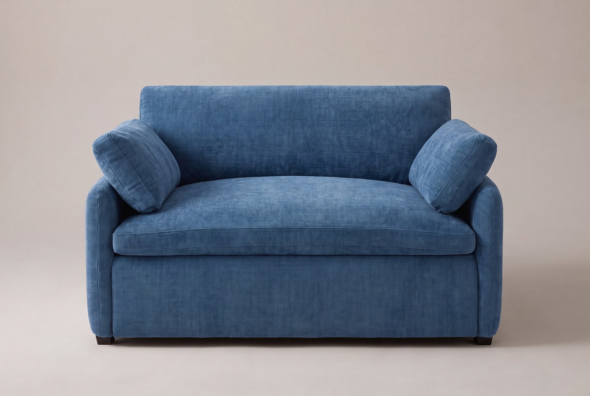 Gallipoli chair in denim blue, straight front view: one wide seat cushion, one back cushion, a pillow on each low rounded arm