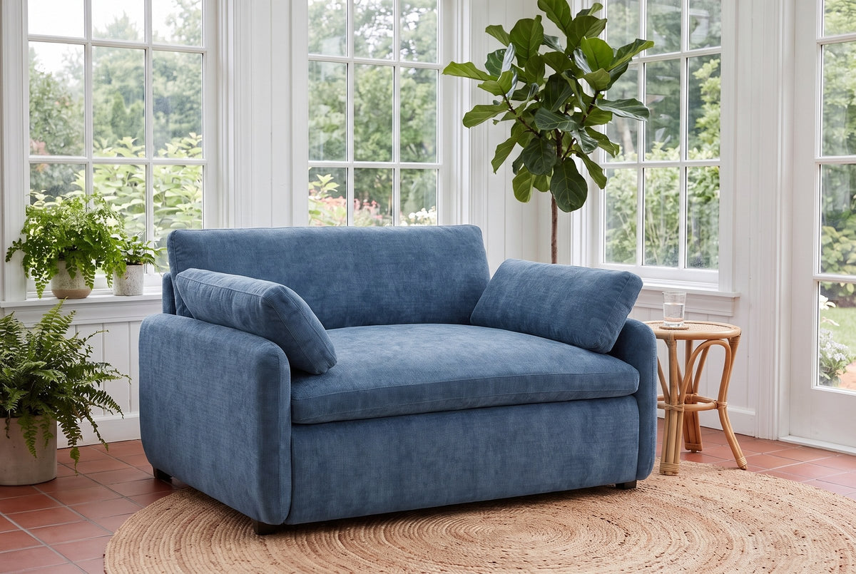Gallipoli chair in denim blue on a jute rug in a Victoria garden room with ferns and tall paned windows