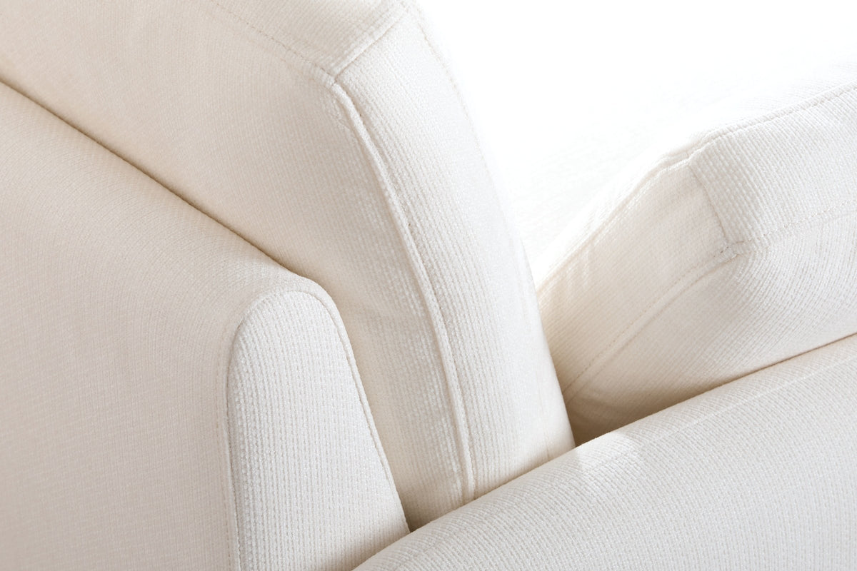 Close-up of the ribbed chenille where the arm, the back cushion and a pillow meet, with their top-stitched edges