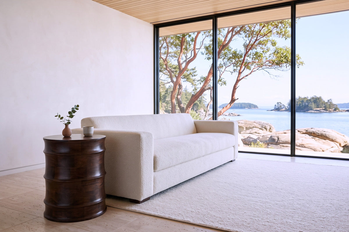 Gangi side table in Walnut at the arm of an ivory boucle sofa in a Nanoose Bay house, with a limewashed wall