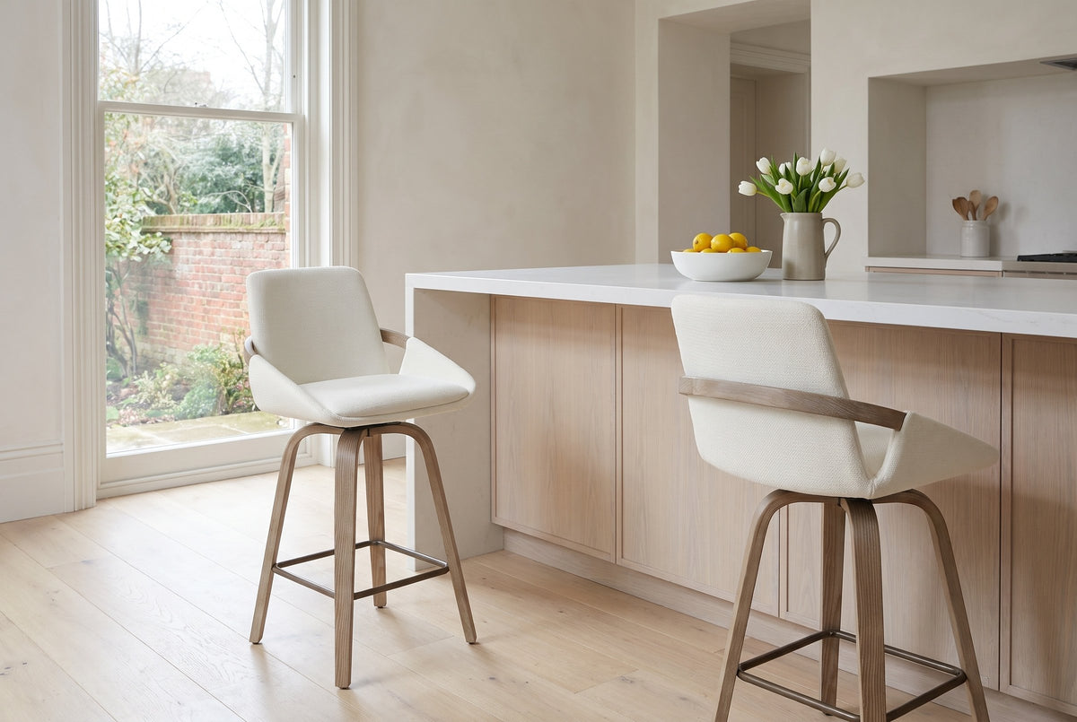 Two Gardone counter stools in ivory at a pale white-oak island with a white stone top in a bright Toronto kitchen