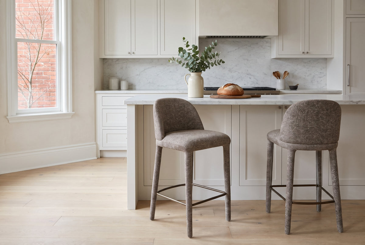 Two Gavi counter stools in brown at a white shaker kitchen island with a marble top in a Toronto Victorian kitchen