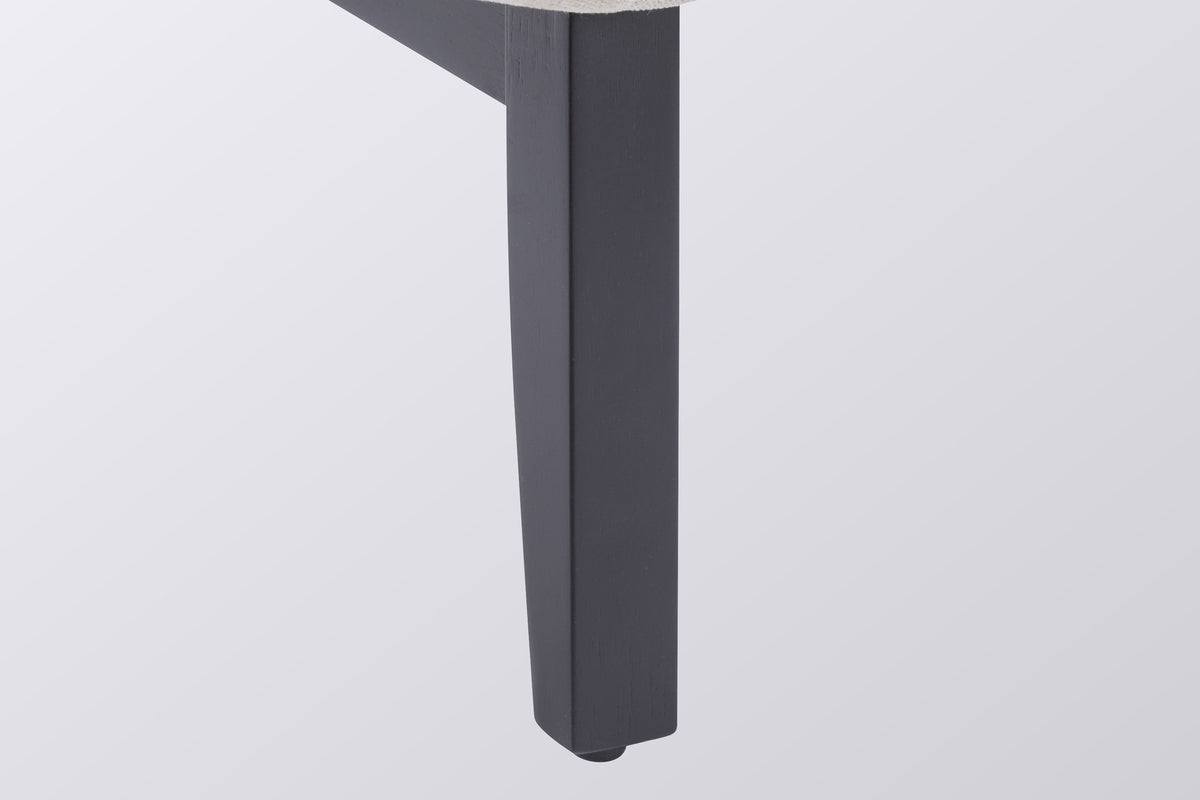 Close-up of a square black-painted leg with its floor glide and the side rail, under the corner of the oat seat