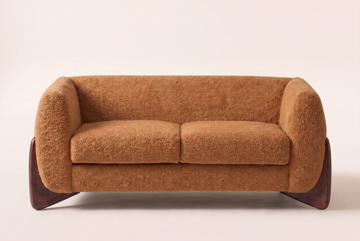 Greccio boucle loveseat in caramel, straight front view with two seat cushions and walnut-stained wedge legs