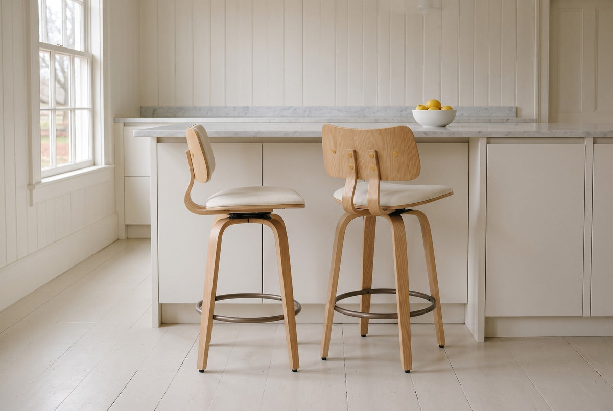 Two Gressoney counter stools in Beige / Natural, one in profile and one from behind, at a white island with a marble top in a panelled Charlottetown kitchen