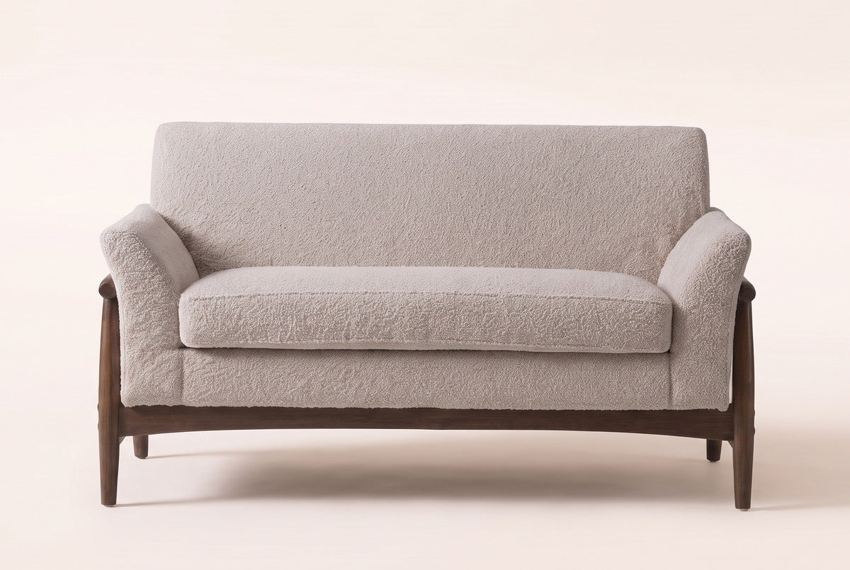 Jesi loveseat in almond boucle, straight front view: one long seat cushion, a tight back, flared arms and an arched wooden apron