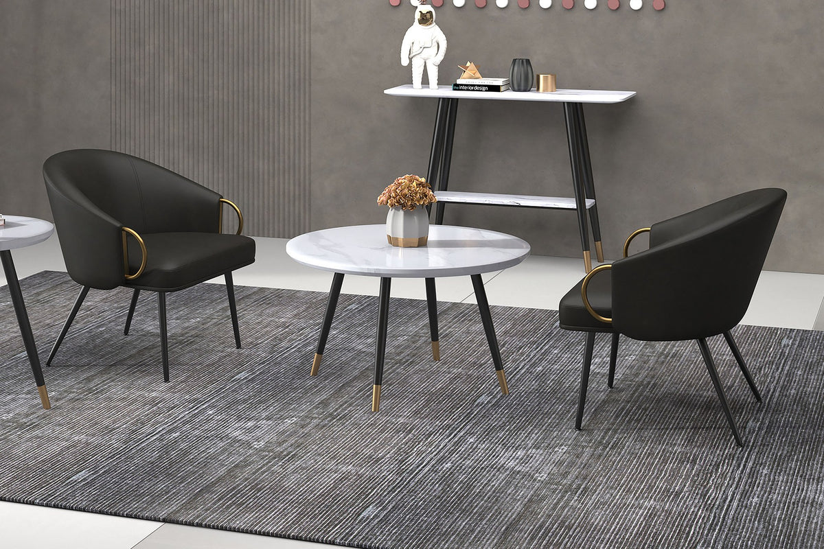 Two Kenna charcoal faux leather chairs around a round marble-top table in a grey room