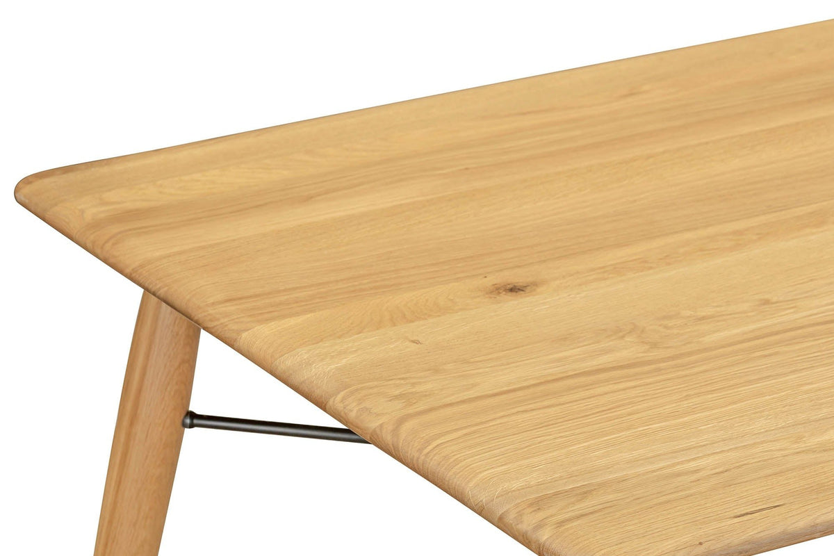 Close-up of a Larino corner in Natural: the rounded corner, the soft edge and a splayed leg