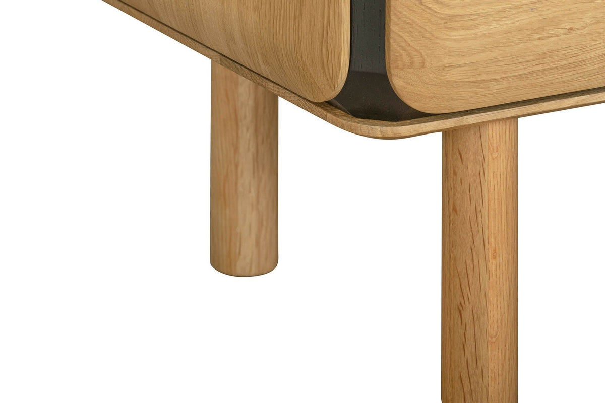 Close-up of a round oak leg under the Larino sideboard in Natural and Black, below the rounded end and the black band