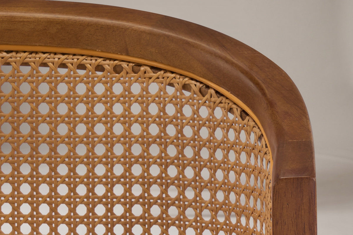 Close-up of the caramel cane-look weave and the walnut-finish wood arch on the back of the Lazise counter stool