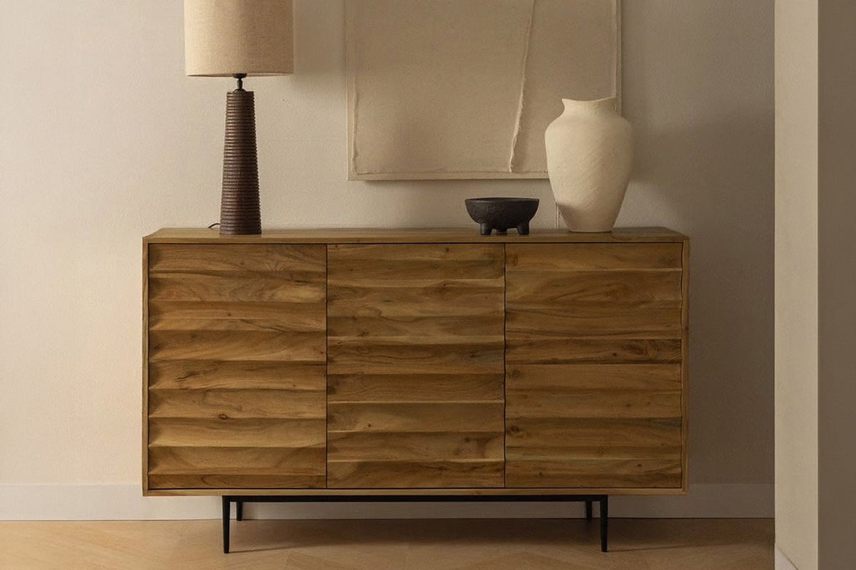 Leander honey acacia sideboard under abstract wall art with a table lamp and ceramics