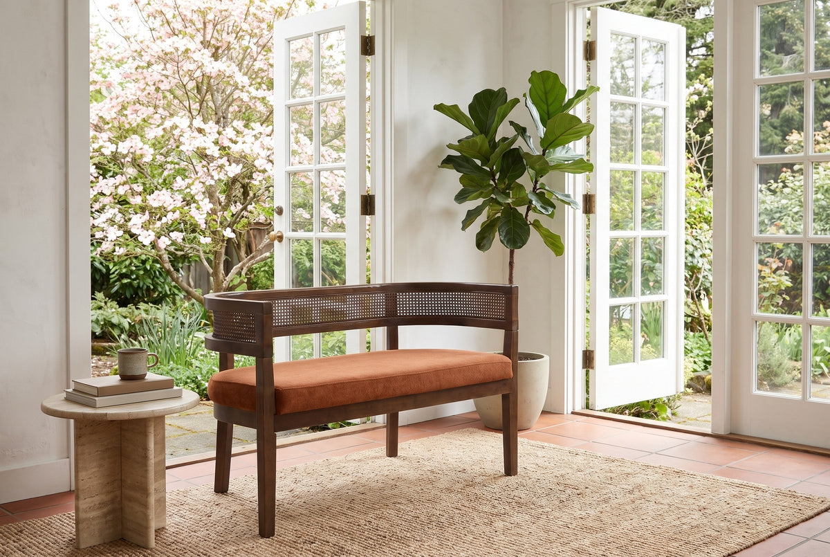 Levanto loveseat in a Victoria garden room with open French doors, a flowering dogwood and a travertine side table