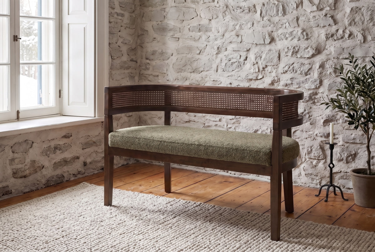 Levanto loveseat in green and walnut against a fieldstone wall in a Quebec City living room in winter light