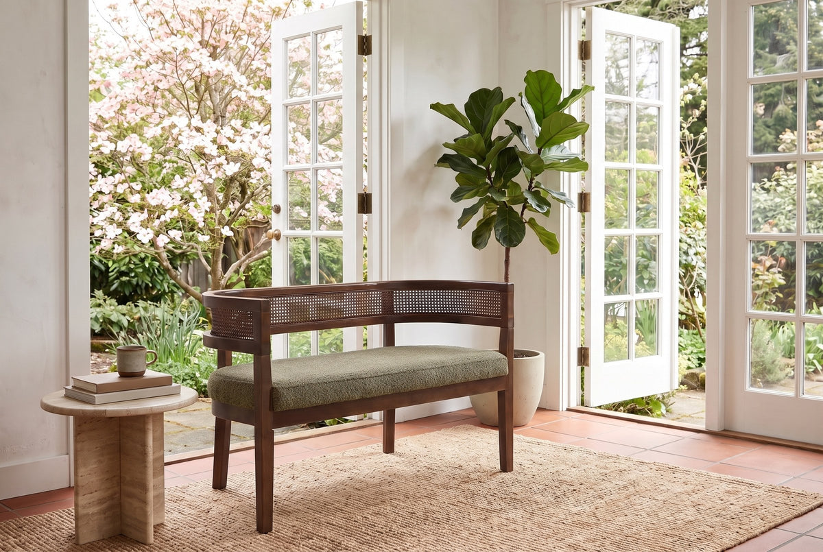Levanto loveseat in green and walnut in a Victoria garden room with open French doors, a flowering dogwood and a travertine side table